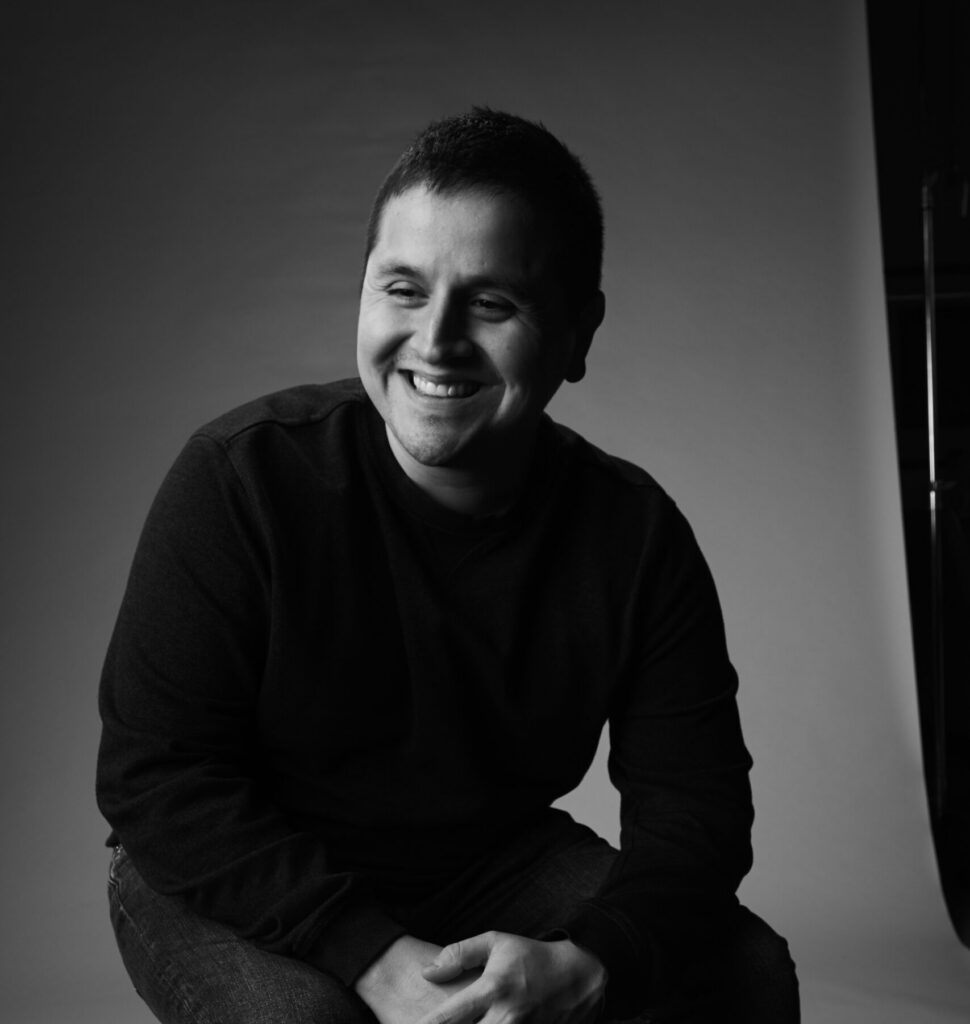 A headshot of a man smiling.