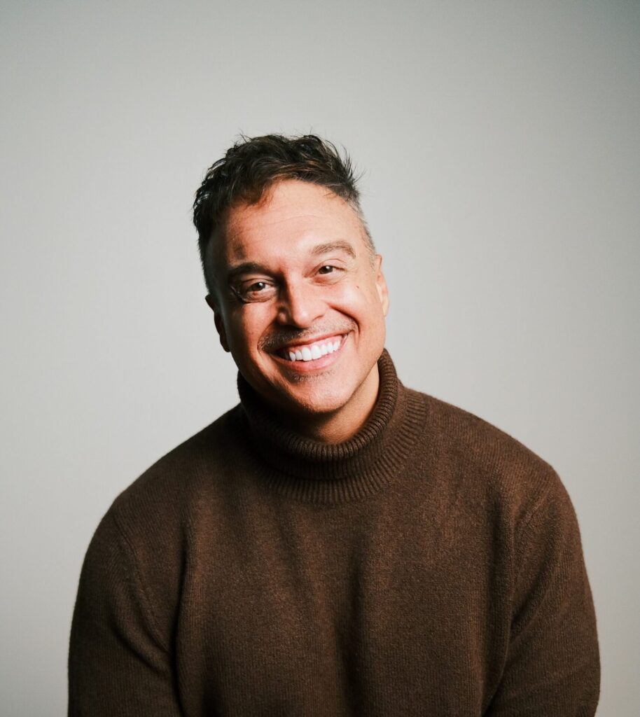 A headshot of a man smiling.