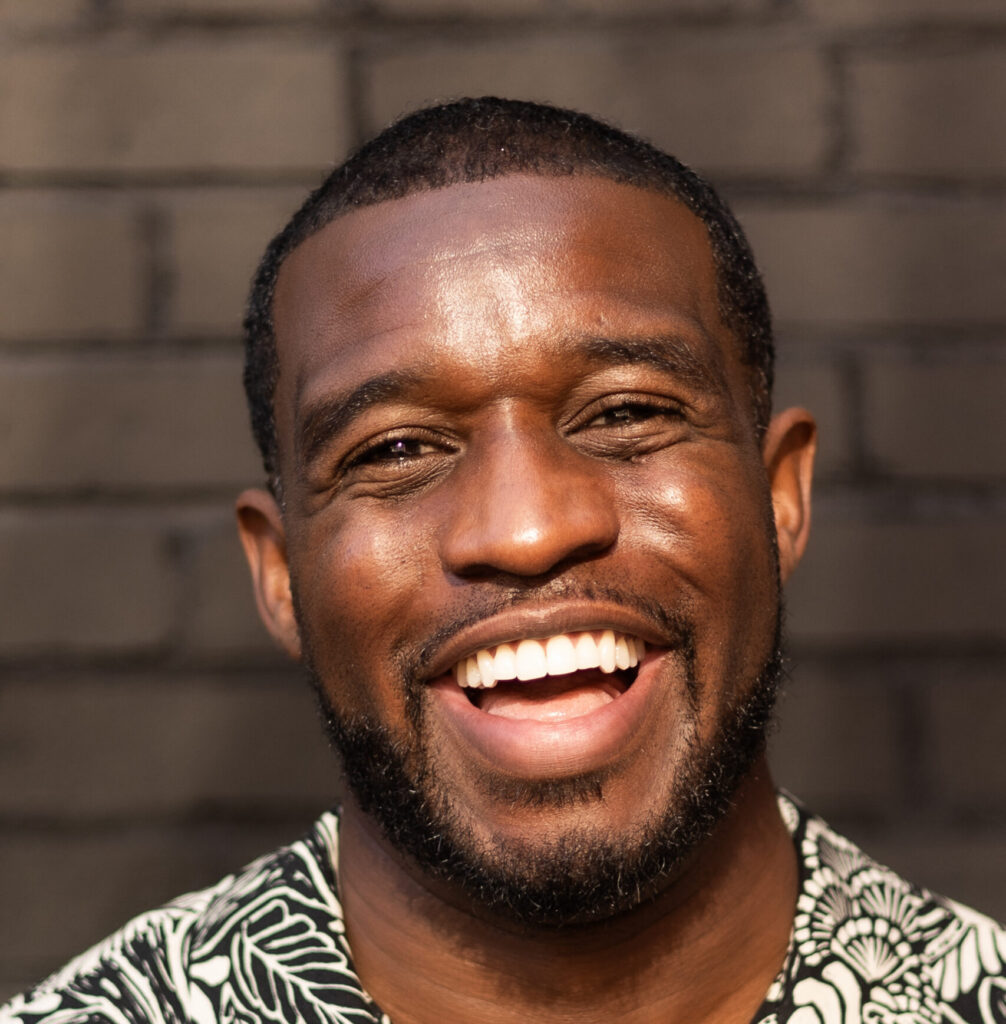 A headshot of a man smiling.